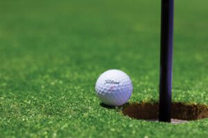 Golf ball going into a hole